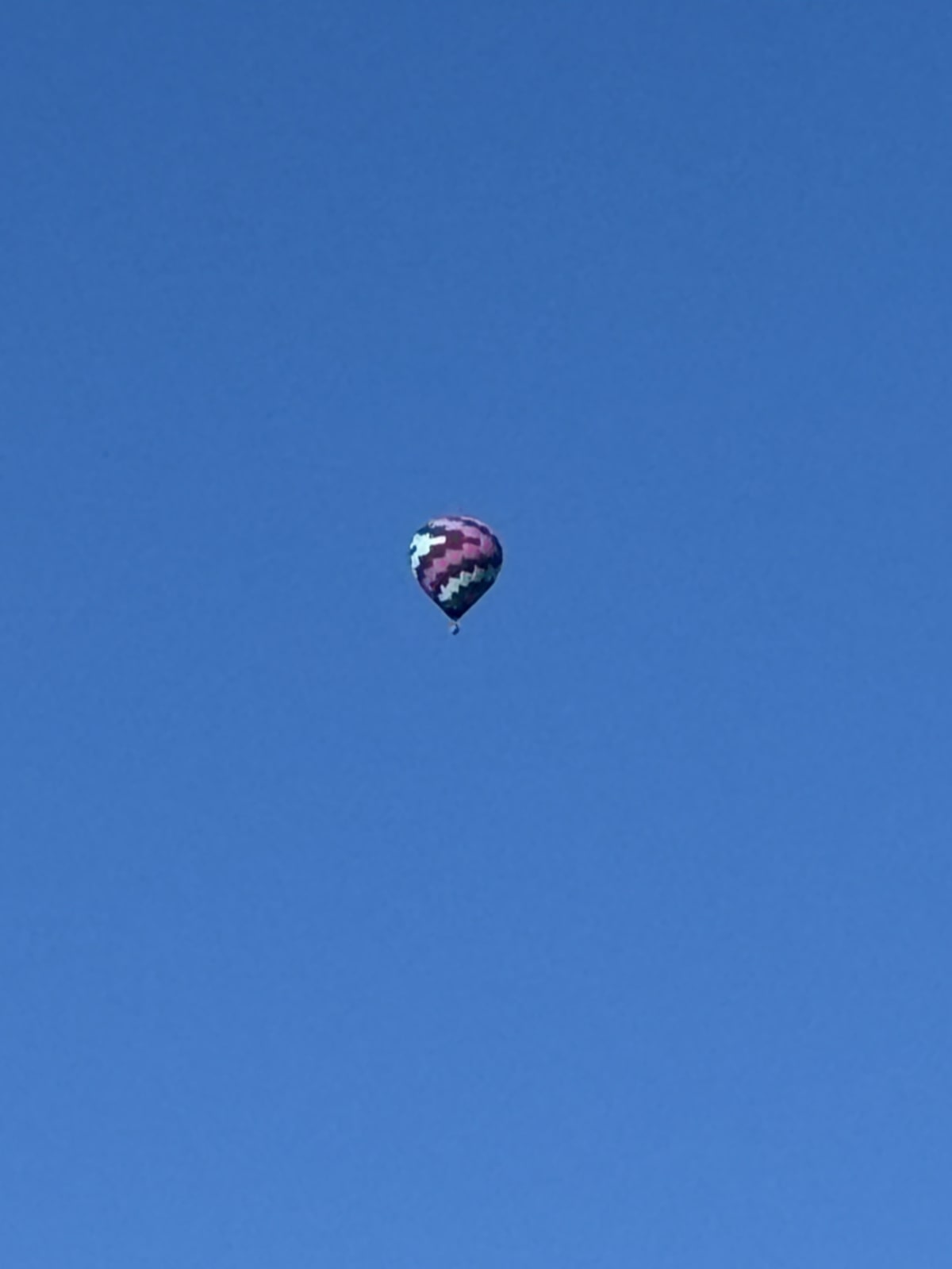 Colorful hot air balloon floating against blue sky