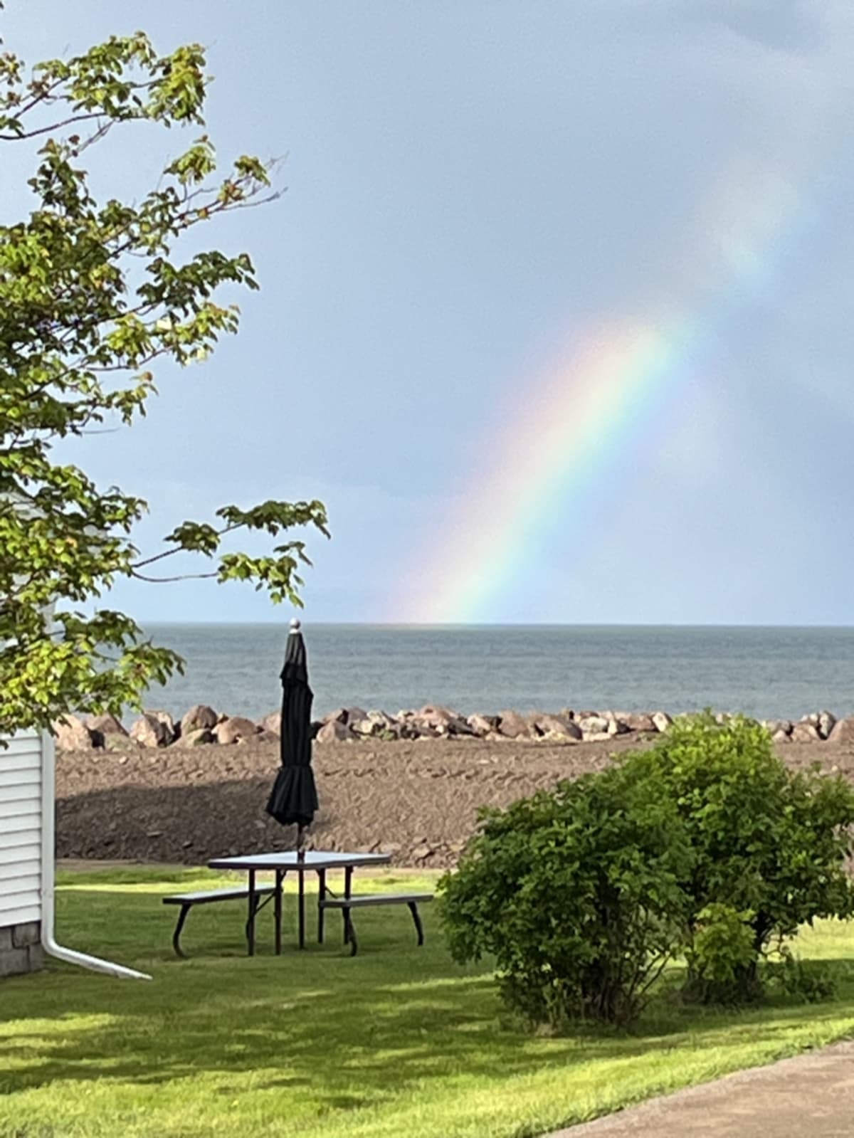 Beautiful rainbow stretching across the beach after rain