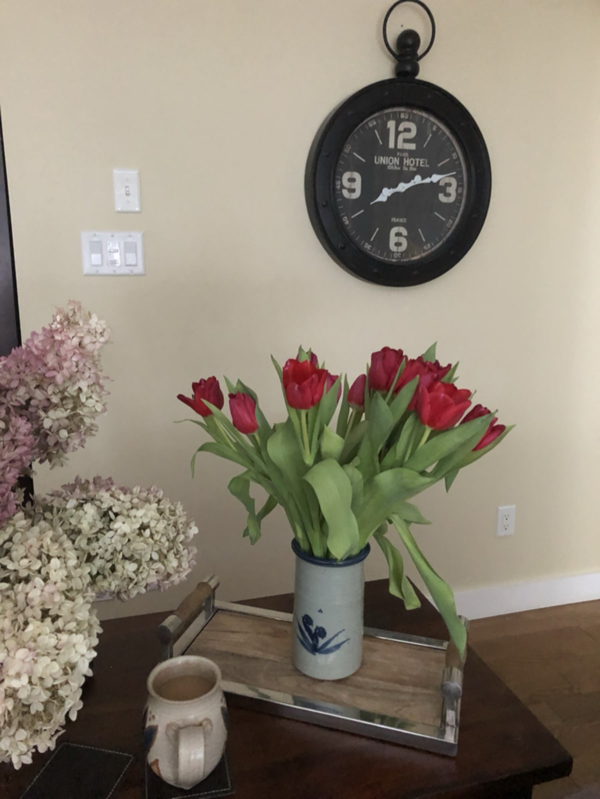 A quiet morning scene with coffee, a clock, and flowers — symbolizing slow travel and taking time