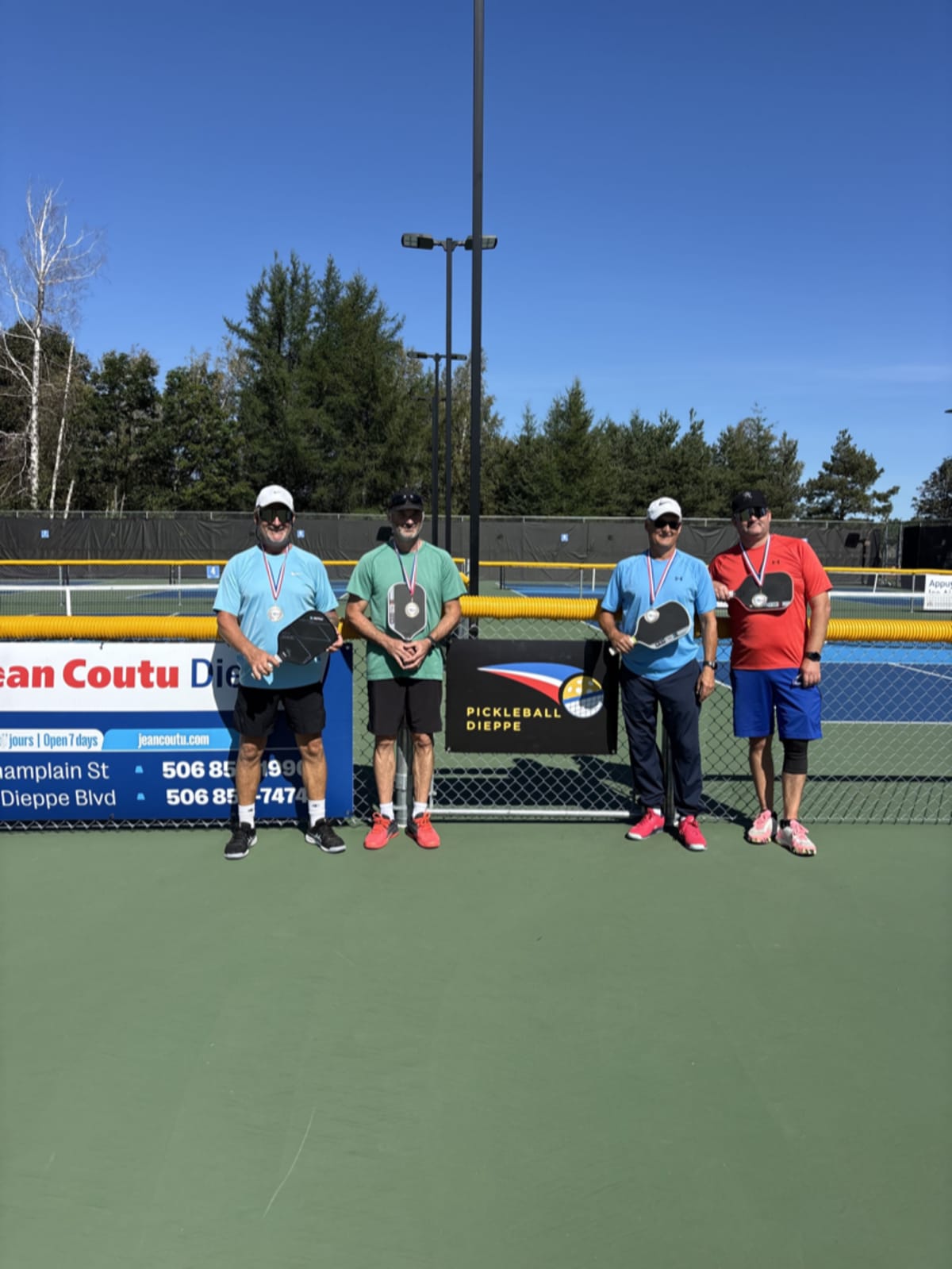 Gold medal winners celebrating together on the pickleball court, the true prize of friendship and teamwork