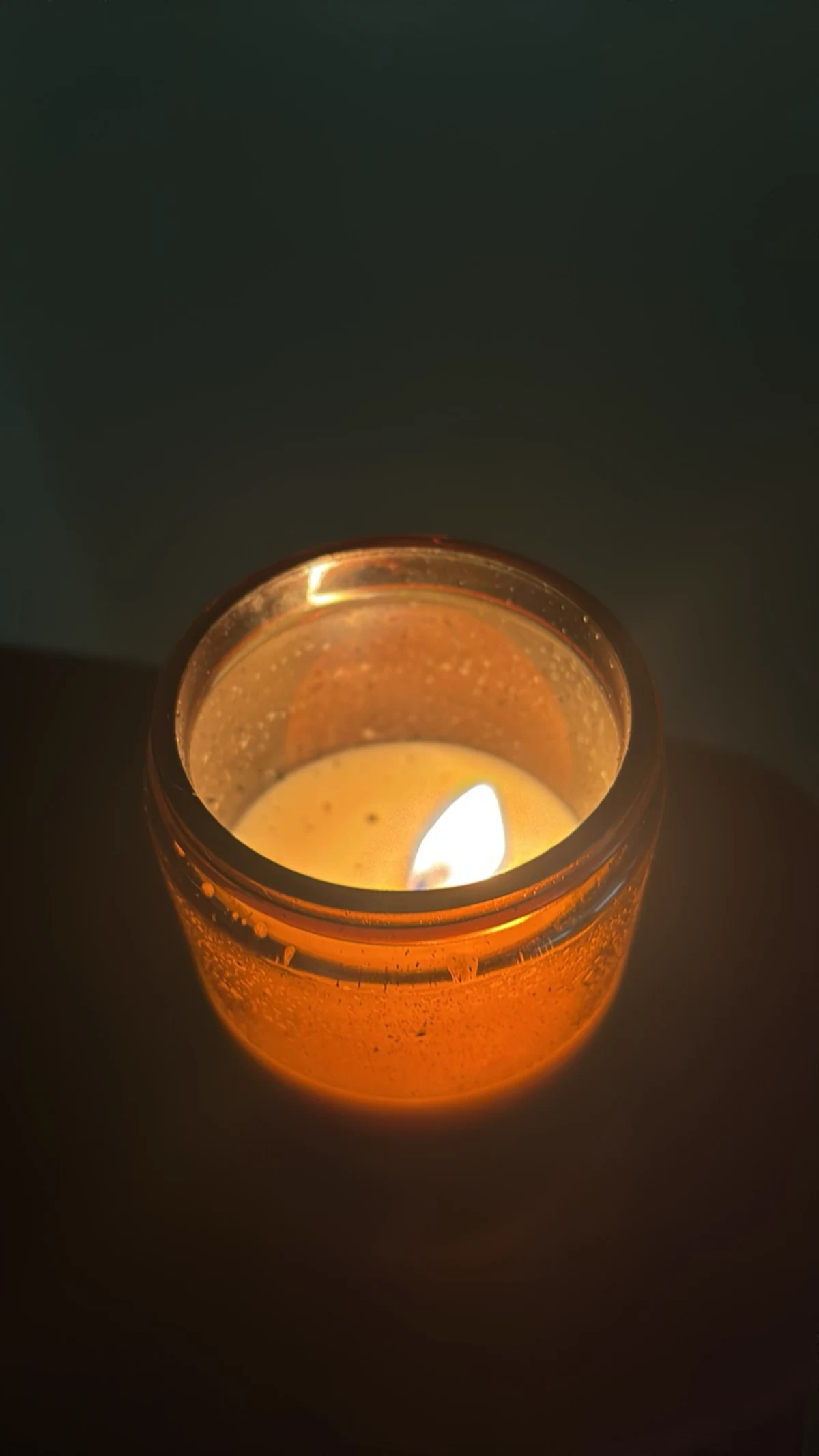 A lit candle glowing warmly - a small light of kindness